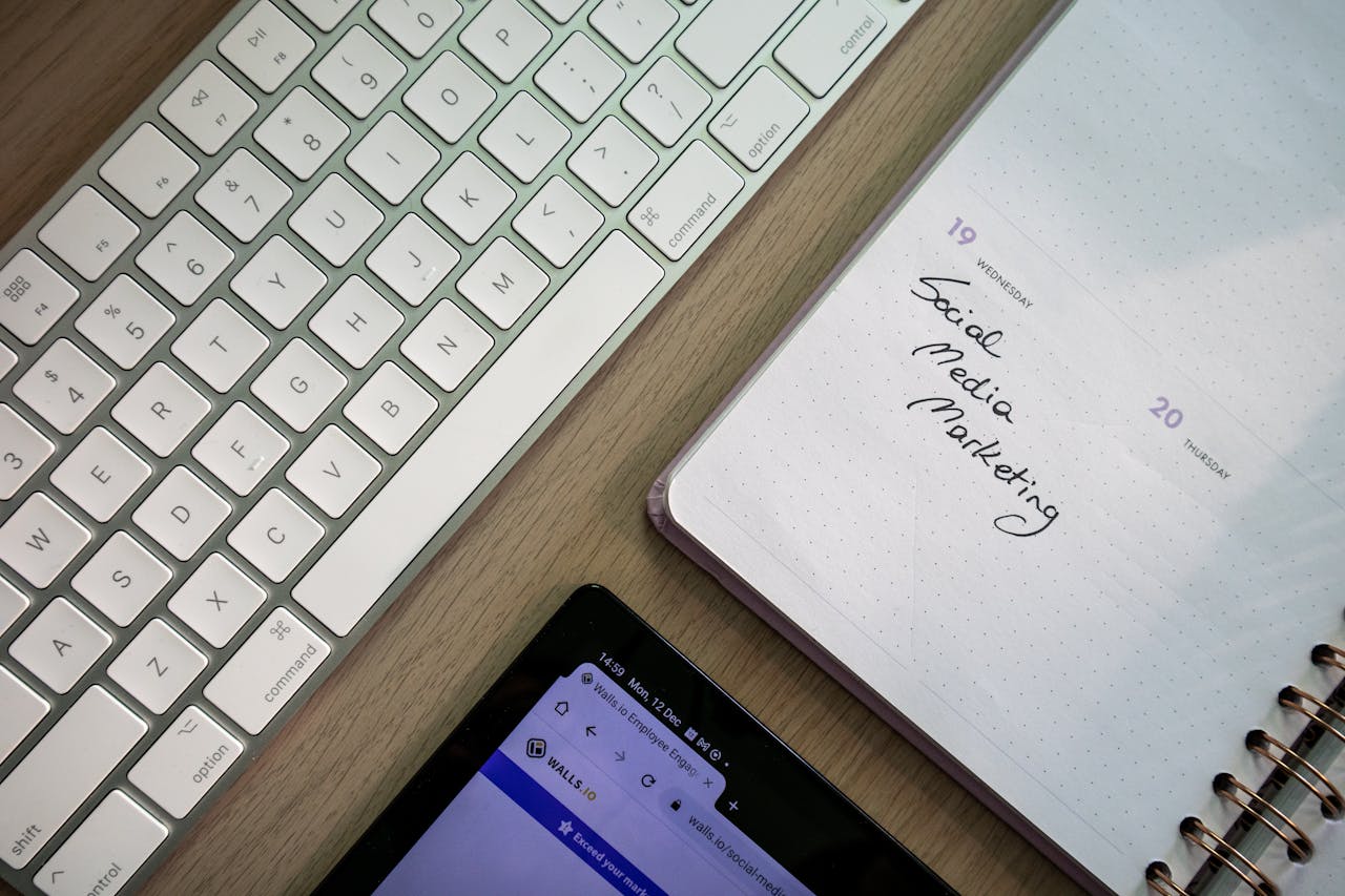Crafting Captivating Headlines: Your awesome post title goes here Top view of keyboard, planner with social media marketing note, and tablet on a desk.
