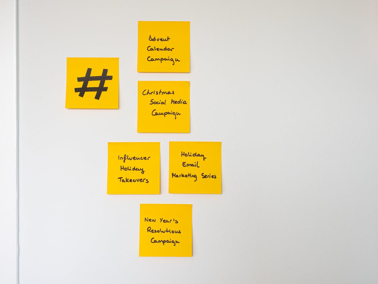 our-story Organized yellow sticky notes on a white wall for holiday marketing strategies.